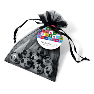 Chocolate footballs wrapped in foil in a ribbon tied bag