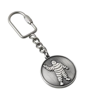 a round metal medal keyring in antique silver and stamped out michelin man design