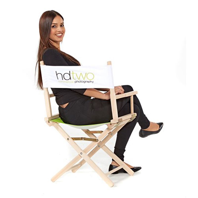 woman sitting on white directors chair with 2 colour corporate branding