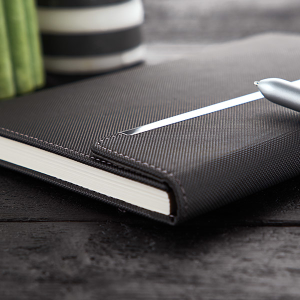 Imitation leather hardcover notebook in black with fold over magnetic lock and stitching detail around edges