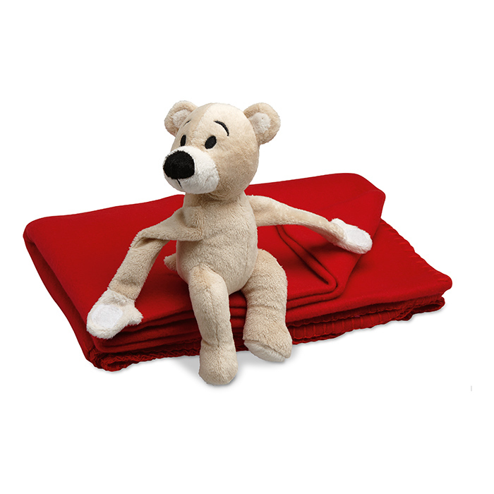 teddy bear sitting on a red blanket