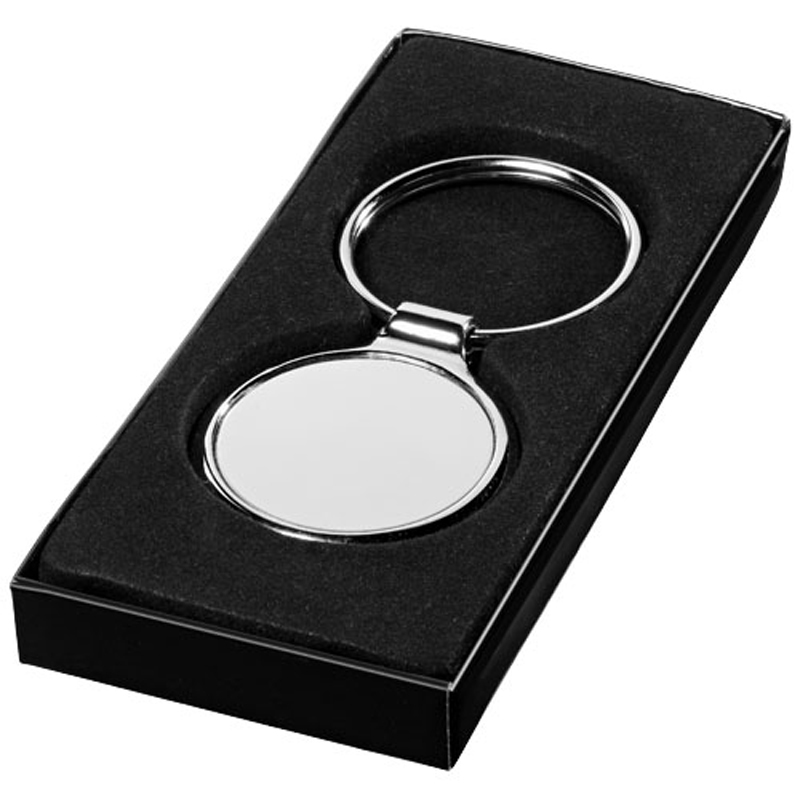 a small round keychain in a black gift box