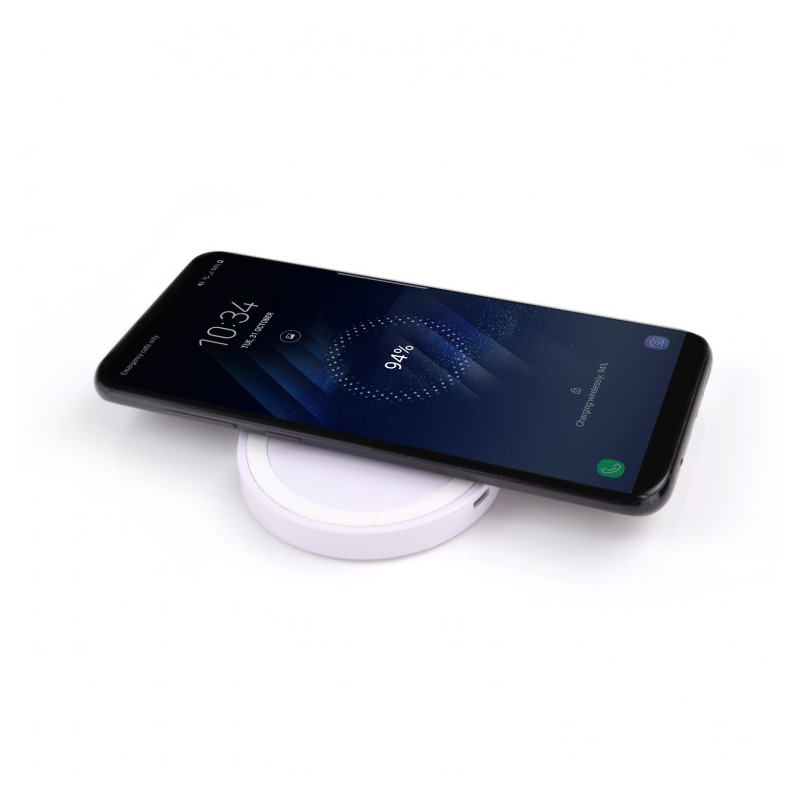 White charging pad topping up a mobile phone