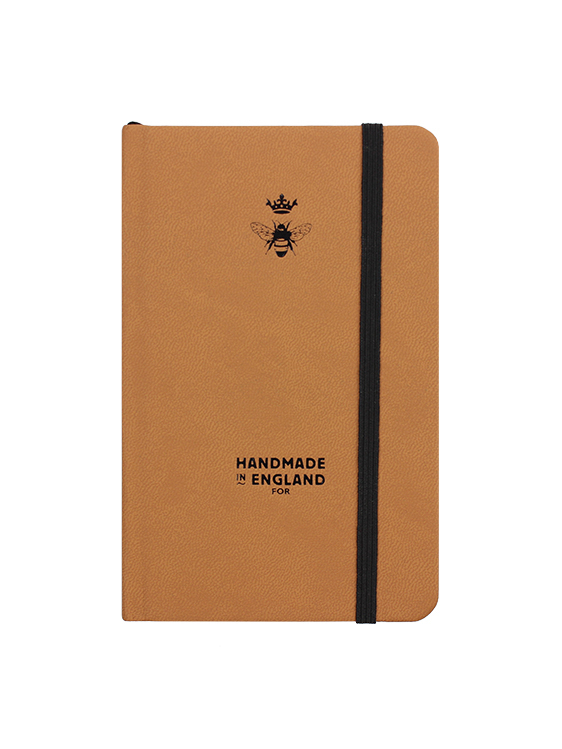 Will Bees Pocket Notebook in tan with black elastic closure strap and black embossed logo