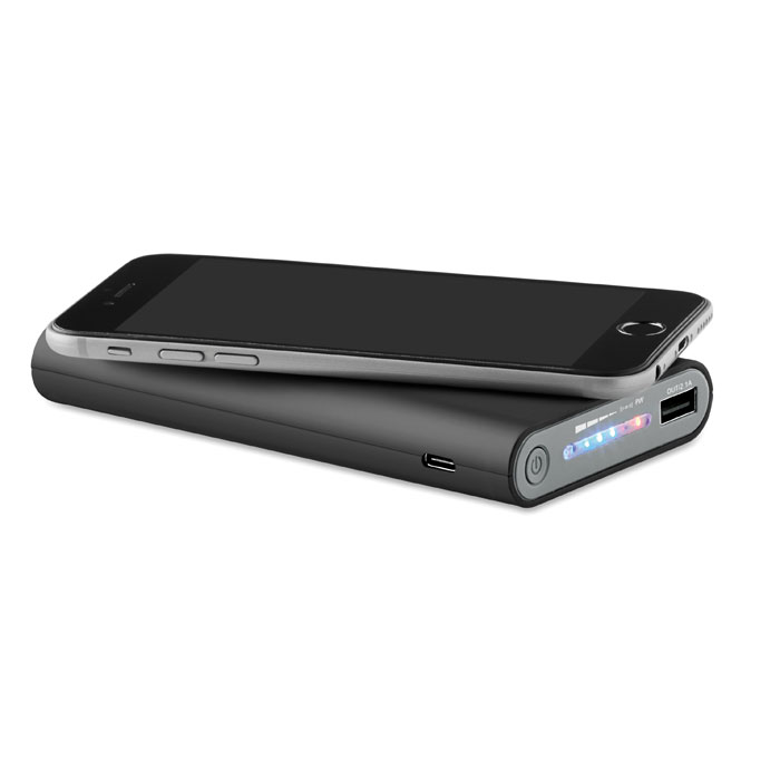 Wireless charging power bank in black with phone on top charging