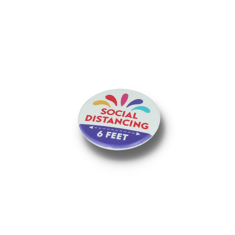 a white round badge promoting social distancing