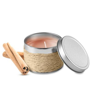 a candle in metal tin next to cinnamon sticks