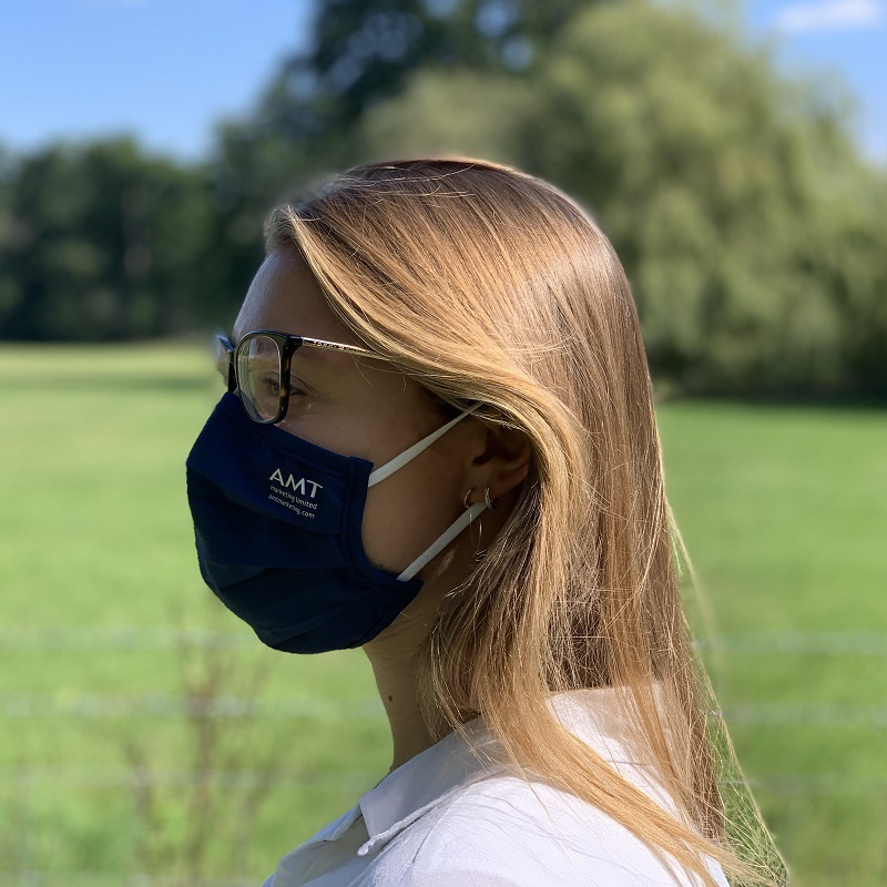 person wearing blue pleated face mask and glasses with branding to one side