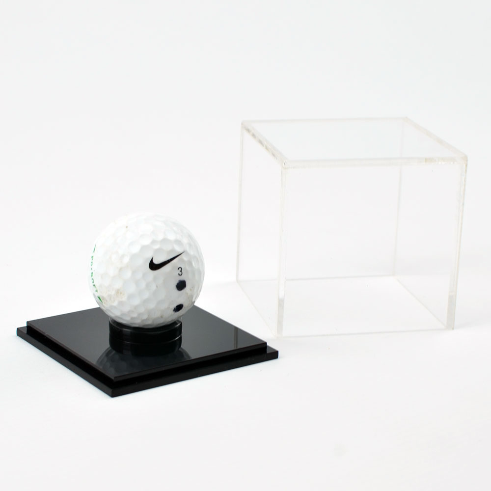 Golf Ball Display Case with gold ball on black base with lid off