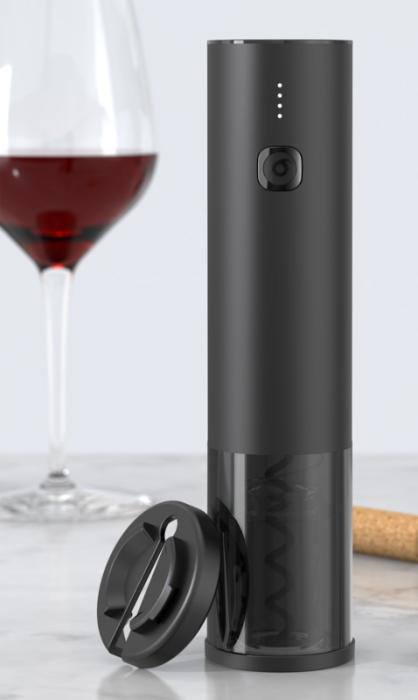 Black electric corkscrew standing with wine in background