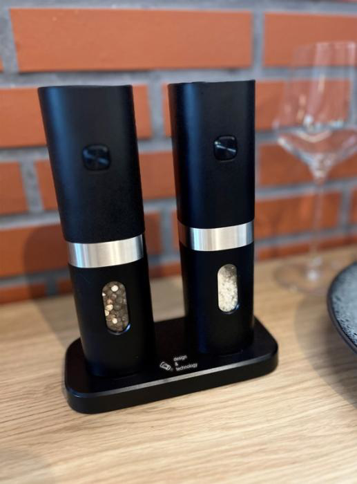 Electric salt and pepper grinder set on charging base