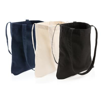 a selection of three tote bags, one white, one navy, and one black 