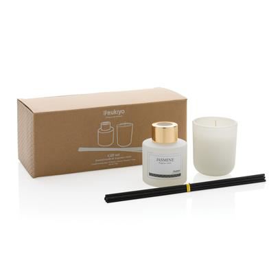 white diffuser with fragrance sticks and a candle and a brown box that the product comes in 