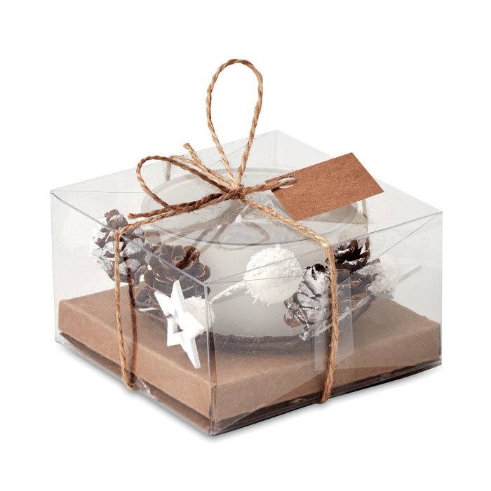 A white christmas candle that has been wrapped up in a box with ornaments and ribbon