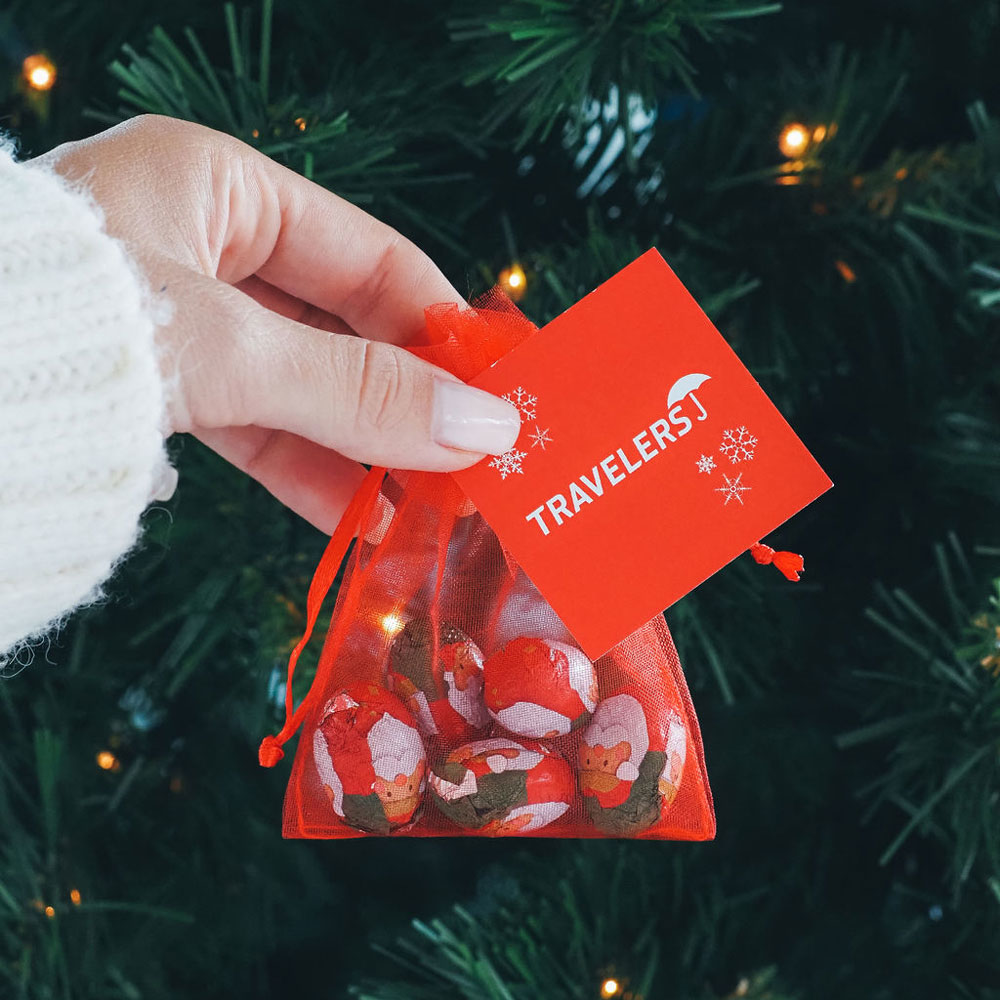 A netted bag in the colour red with a personalised tag 