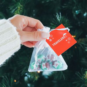 A netted bag in the colour white with a red personalised tag 