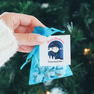 A netted bag in the colour  blue with a white personalised tag 