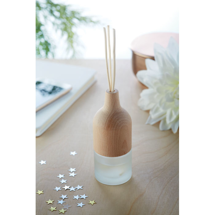 a transparent diffuser with a brown top and brown fragrance sticks on display on a table 